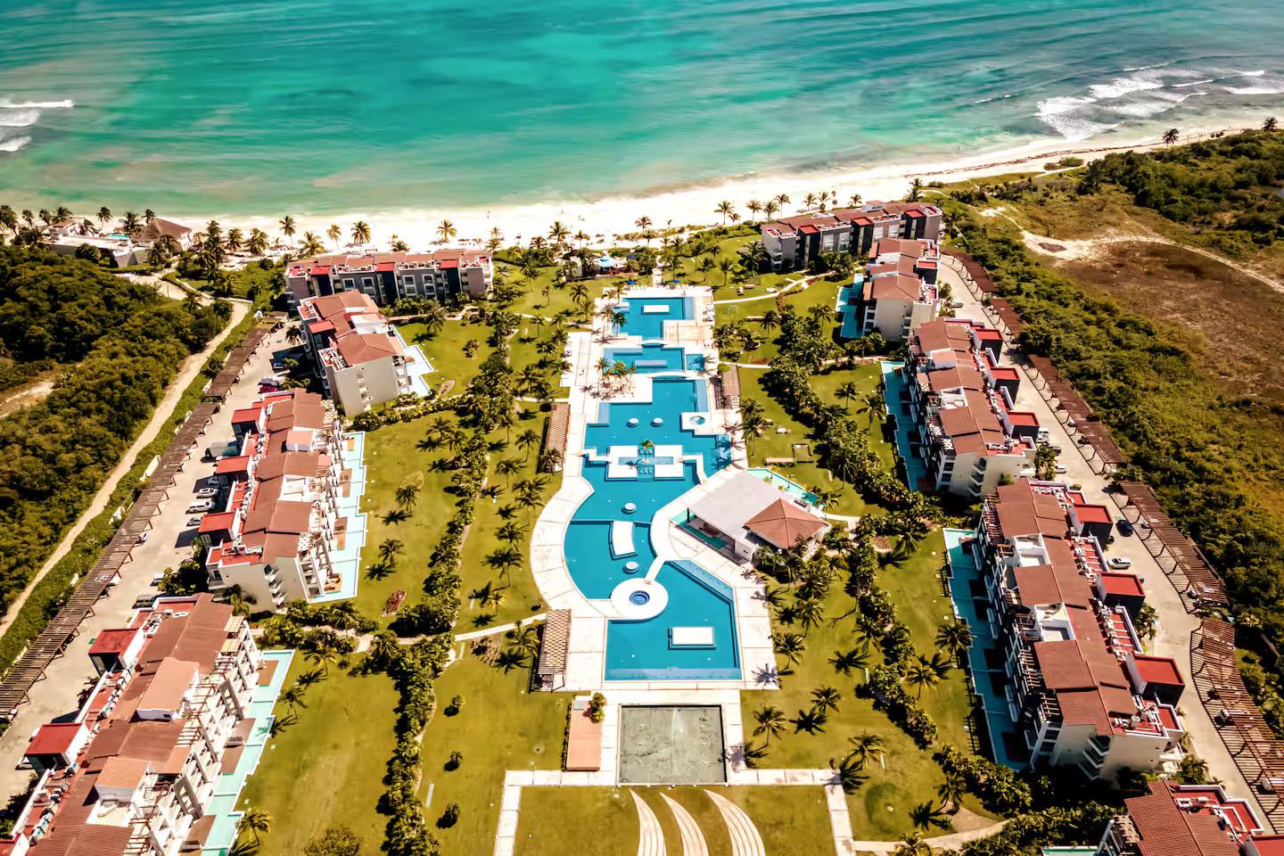 Aerial view of Mareazul: buildings in a horseshoe around the central pool, opening to the sea